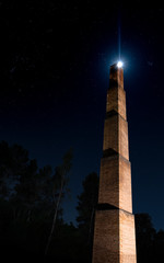 Moonlit brick chimney at its upper vertex