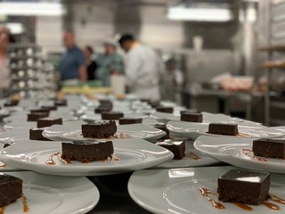 Pastry chef is cooking many chocolate cakes. Cruise ship galley dessert section.