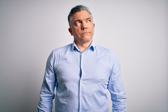 Middle age handsome grey-haired business man wearing elegant shirt over white background smiling looking to the side and staring away thinking.