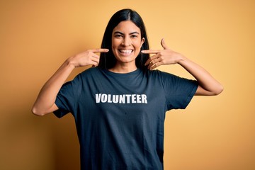 Young beautiful hispanic woman wearing volunteer t-shirt as social charity moral smiling cheerful...