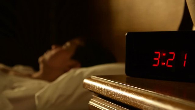 Woman with insomnia lying in bed at night .