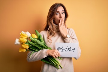 Beautiful brunette woman holding best mom message and tulips celebrating mothers day cover mouth with hand shocked with shame for mistake, expression of fear, scared in silence, secret concept