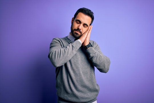 Handsome businessman with beard wearing casual tie standing over purple background sleeping tired dreaming and posing with hands together while smiling with closed eyes.