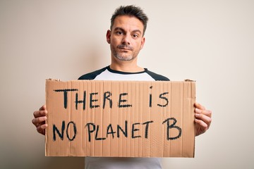 Young handsome man asking for environment holding banner with planet message with a confident expression on smart face thinking serious