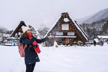Young woman traveler enjoying with snow at shirakawa-go in winter