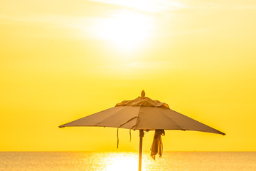 Beautiful tropical nature umbrella chair with palm tree around beach sea ocean at sunset or sunrise