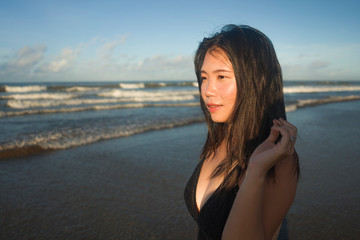 natural lifestyle portrait of young attractive and happy Asian Korean woman in swimsuit walking on beautiful beach paradise feeling relaxed and cheerful enjoying holidays