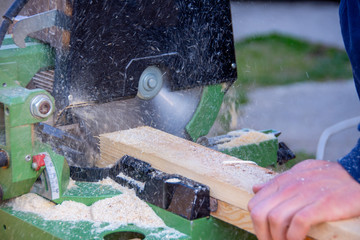 Man cutting wood using circular saw to create different products out of wood