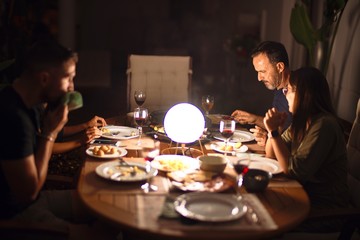 Beautiful family on dinner talking and smiling at terrace