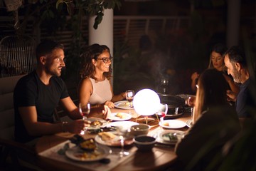 Beautiful family on dinner talking and smiling at terrace