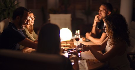 Beautiful family on dinner talking and smiling at terrace