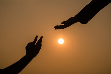 Giving a helping hand on the background of the sunset.