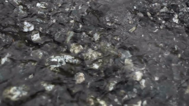 Water flows on pebbles, extreme close up, shallow DOF
