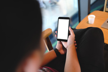 Close up of man using cell phone,sending massages on the coffee shop with black screen,texting,video calls.