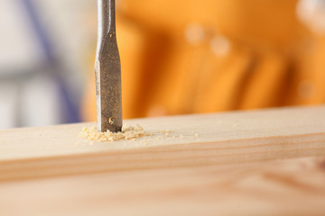 Flat drill bit make hole in wooden bar closeup. DIY job inspiration improvement fix shop powersaw bench joinery startup workplace idea career shaving industrial education concept