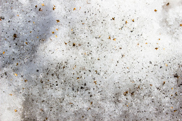 Snow with dust from the road. Dirty snow. Spring.