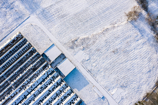 abandoned and broken snow-covered greenhouse in the countryside. top view aerial photo