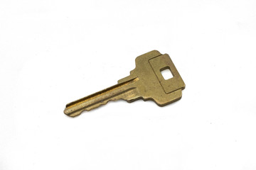 A brass house key, close up, isolated on a clean, white background.  Shot in macro.