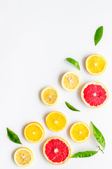 Citrus slices frame - lemons, grapefruits, leaves - on white background top-down copy space