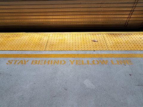 Yellow Tactile Bumps And Train And Stay Behind Yellow Line Sign