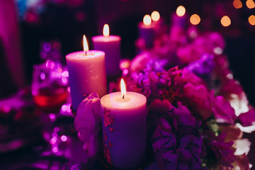 candles stand on the festive table next to the flowers