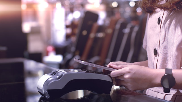 Young Asian Woman Using Mobile Phone - Smartwatch To Purchase Product At The Point Of Sale Terminal In A Retail Store With Near Field Communication Nfc  Radio Frequency Identification Payment