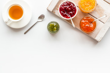 Fruit jam near tea on white kitchen desk frame copy space