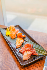 Japanese food, a set of sushi put on a rectangular plate placed on wooden table
