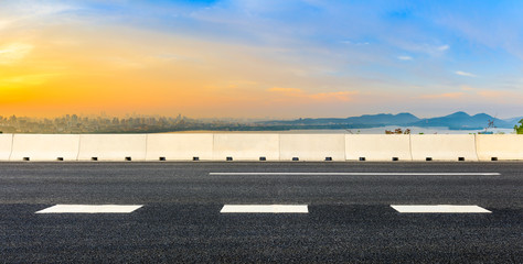 Fototapeta premium Empty asphalt road and city skyline at sunrise in Hangzhou,China.