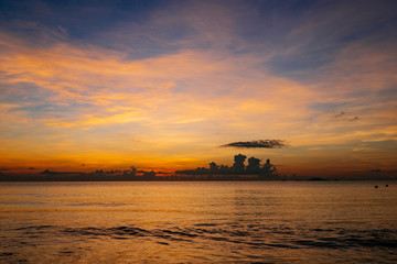 Fototapeta na wymiar Sunrise, sunset of the sun through the clouds, tropical area near sea.