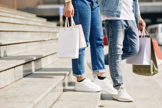 Cropped image of couple walking down the stairs of mall after shopping together