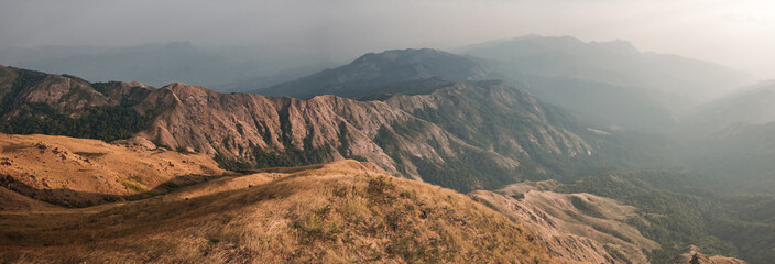Fototapeta na wymiar Panorama scenic mountain peaks and ridges stretching during the evening. , Golden grass moving on wind. At Mulayit Taung in Myanmar. is soft focus.