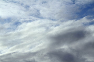 Obraz premium Cloudy blue sky with white and gray clouds. Background for text and design