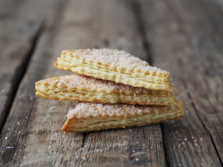 Homemade shortbread puff pastry Triangle on a wooden ancient rustic background. Side view. Place for text.