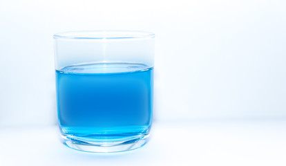 Blue drink water in clear glass on white background
