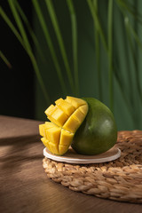 cut mango on tropical background