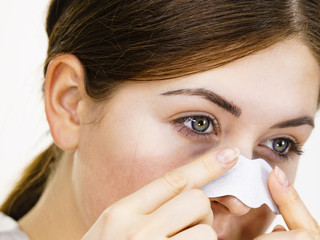 Woman applying pore strips on nose
