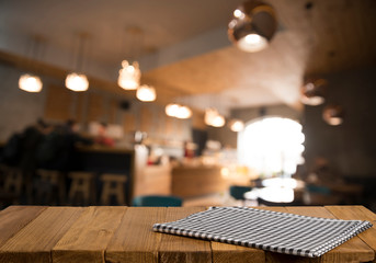 Empty brown wooden table and blur background of abstract of resturant lights people enjoy eating ,can be used for montage or display your products
