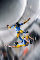 Communication. Two men float in the air. Tandem skydivers are engaged in aerial fitness.