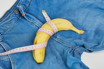 Ruler, banana and condom on jeans 
