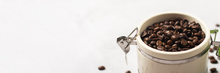 jar with fresh coffee beans and coffee beans are scattered on a concrete background. Banner. Concept of fresh coffee, breakfast, plantation. Top view, flat lay