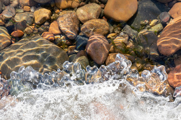 Spring background: curly edge of melting ice, clear river water