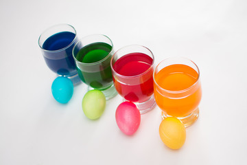 Easter eggs. Coloring eggs with colored liquid dyes in a glass goblet.