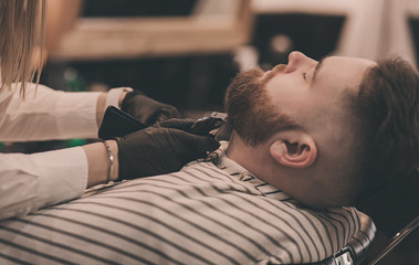 men's haircutting with beard clipper in a barber shop or hair salon