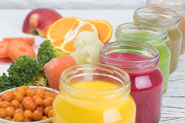 Assortment of jars with tasty baby food on wooden table. vegetable and fruit purees.