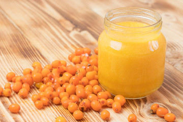 baby sea buckthorn puree in a jar on a wooden table. baby food.