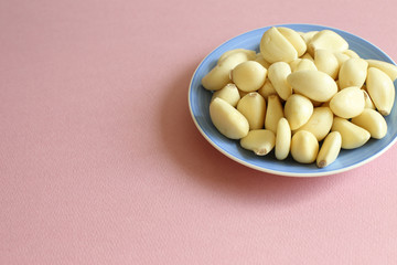 Organic garlic on dish with pink background