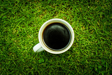 A cup of coffee on green grass