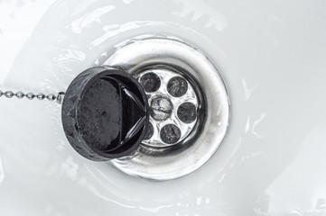 Sharply open drain plug for the bathroom. The whirlpool of water.