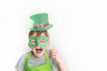 St Patrick's Day holiday concept. Joyful caucasian boy with green paper leprechaun hat and glasses...